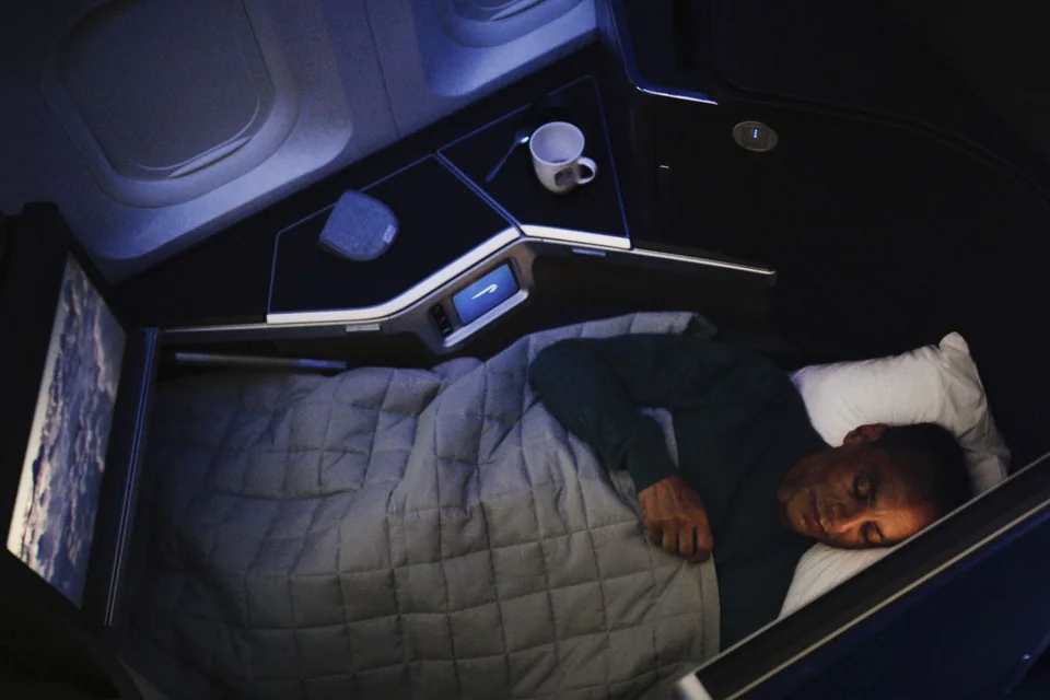 Pasażer śpiący w płaskim łóżku British Airways Club World